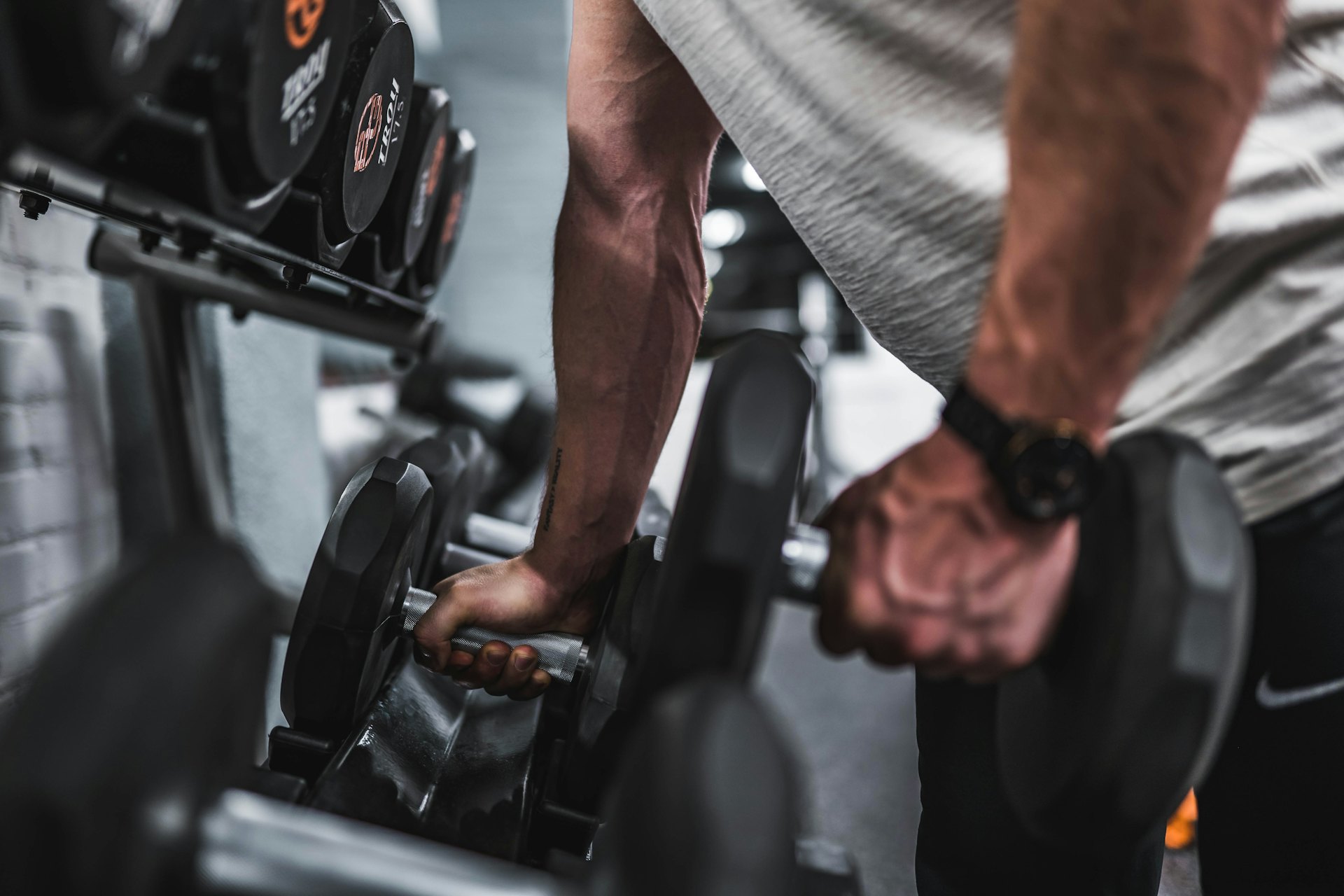 Manos sujetando mancuernas en un gimnasio